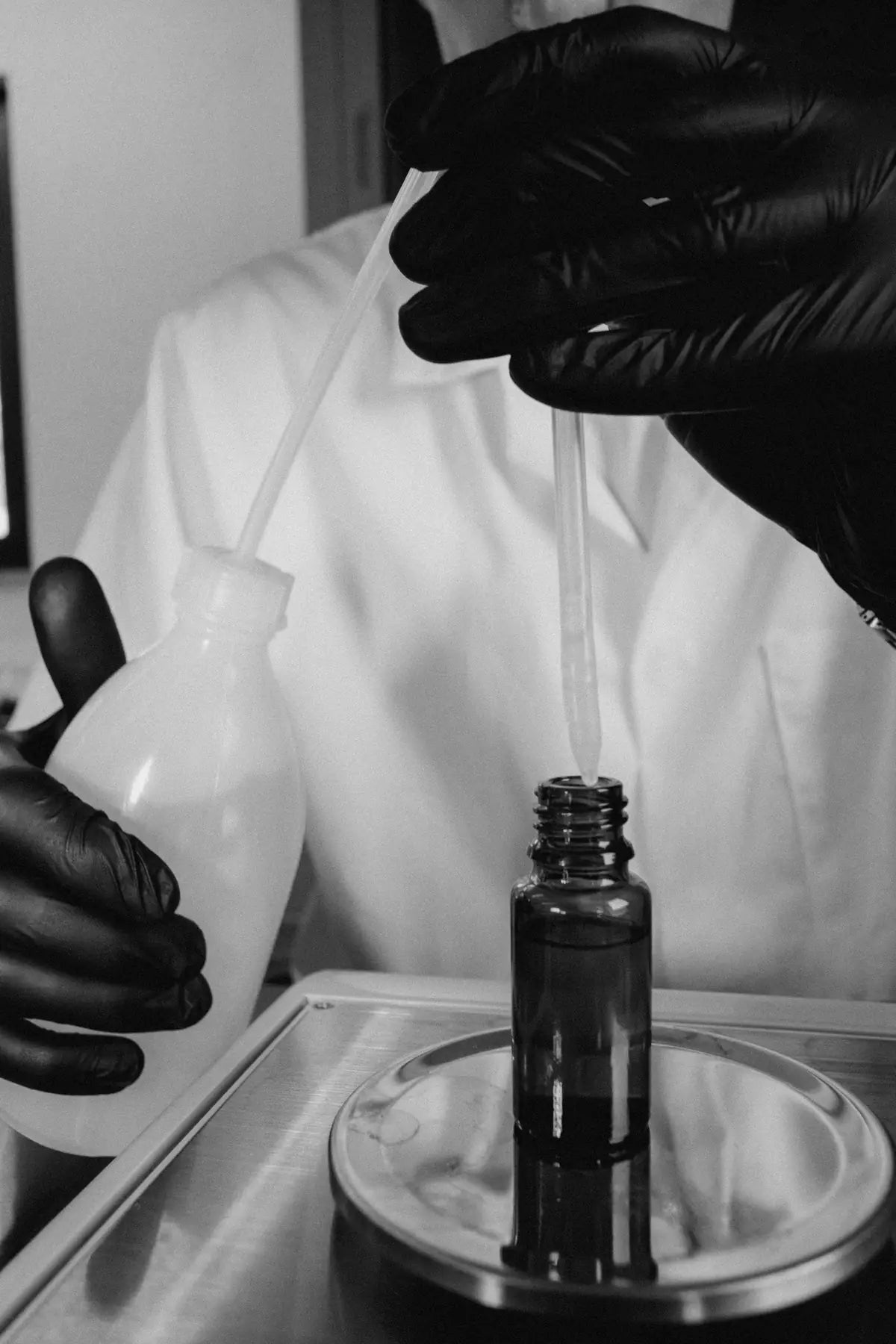 rodi çiçek tropft mit einer pipette einen rohstoff in ein fläschchen auf der feinwaage